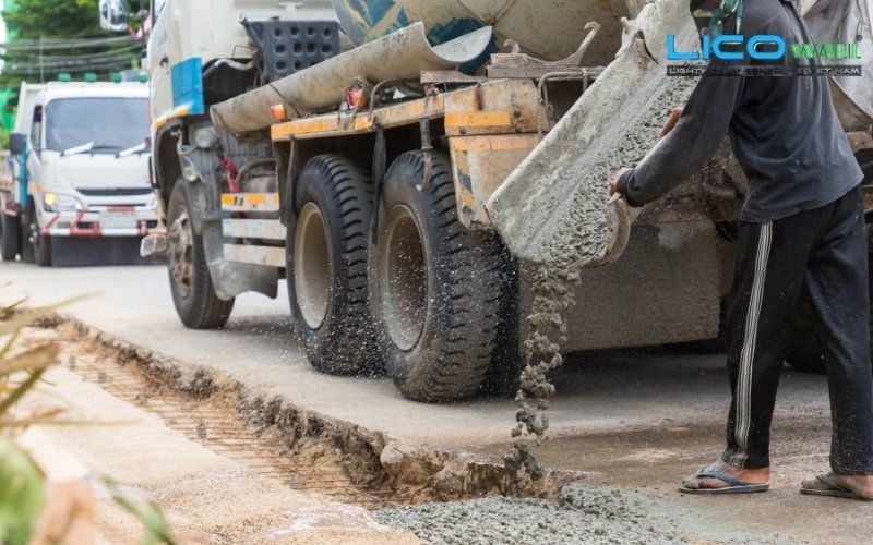 Xe chuyên dụng dẫn bê tông tươi đổ xuống trực tiếp mặt đường cần thi công