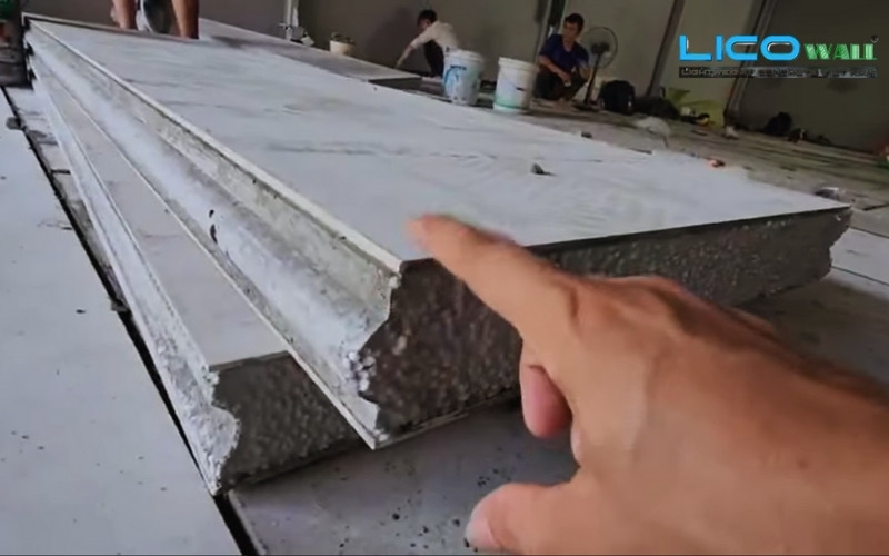 Tay nhân công đang kiểm tra độ dày bê tông nhẹ EPS
