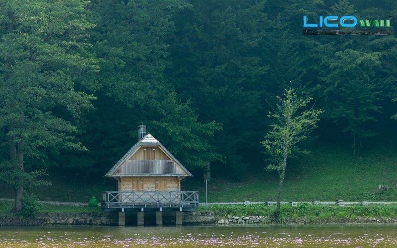 Nhà sàn bê tông bên hồ nước trong rừng cây