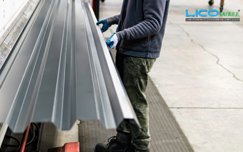 Một nhân viên đang vận chuyển tấm tôn làm sàn deck